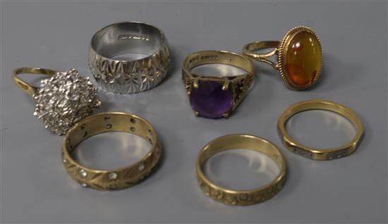 Four various 9ct gold textured rings, one gypsy-set, a 9ct gold and amethyst ring, a similar amber ring and a modernist ring (7).